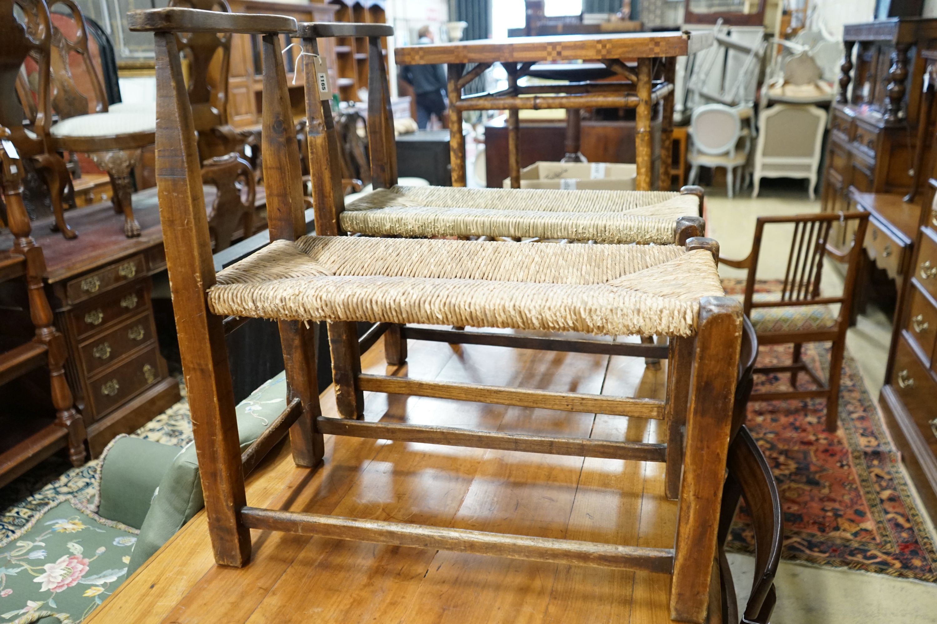 A pair of French provincial oak and beech stools with elongated rush seats, width 31cm, length 67cm, height 73cm
